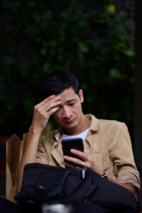 Man looking stressed while using phone.