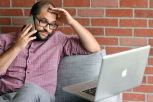 Worker looking at a laptop thoughtfully