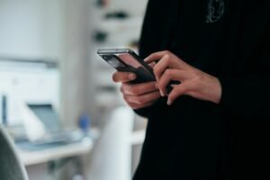Silhouette of a person holding a smartphone as Android users adjust to the switch from Google Assistant to Gemin