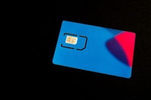 Blue physical SIM card with a gold chip on a dark background