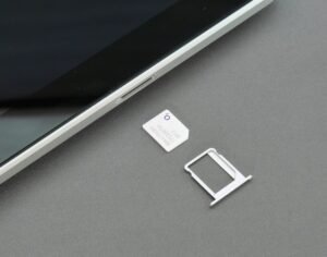 Smartphone SIM tray and ejector tool illustrating the transition to eSIM technology.