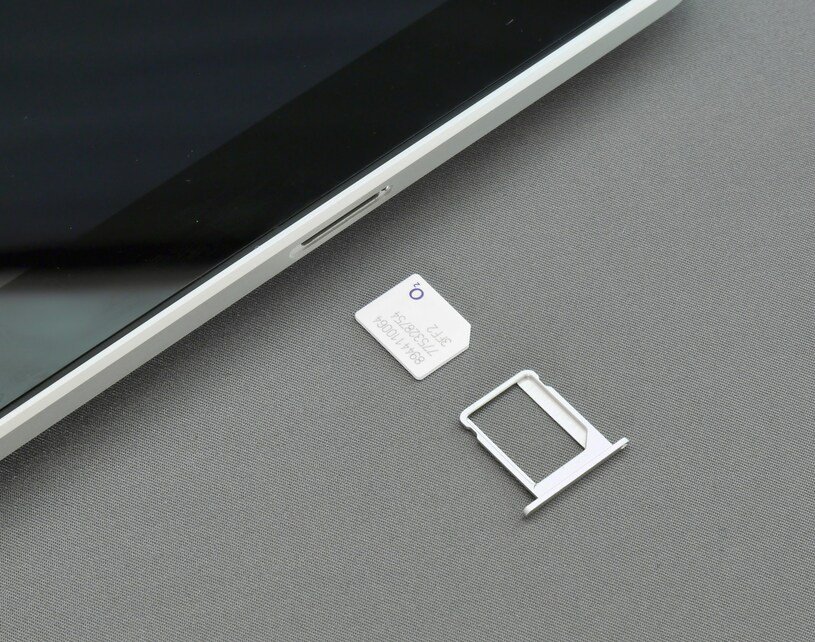 Smartphone SIM tray and ejector tool illustrating the transition to eSIM technology.